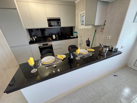 a kitchen with a black countertop and white cabinets
