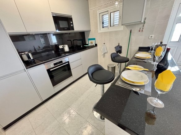 a kitchen with black countertops and white cabinets