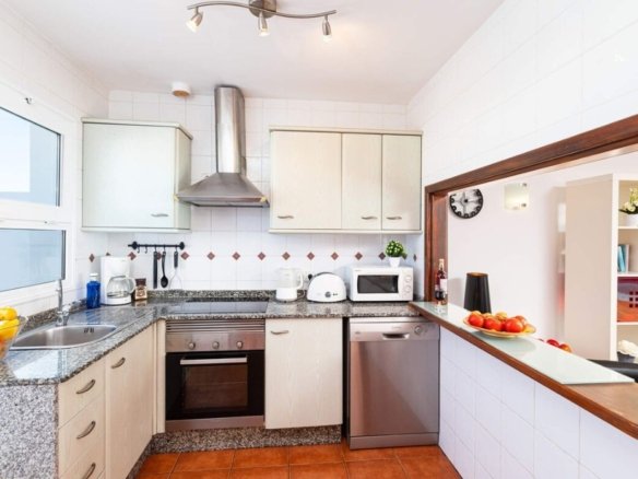 a kitchen with white cabinets and appliances