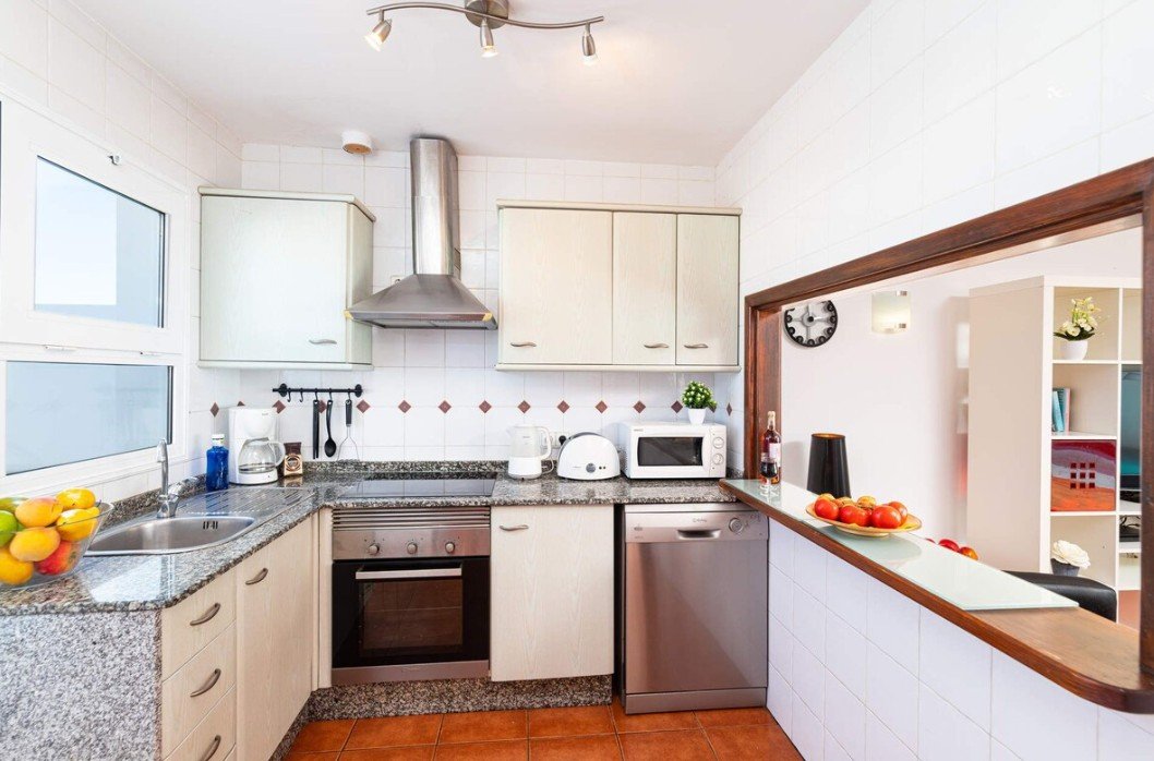 a kitchen with white cabinets and appliances
